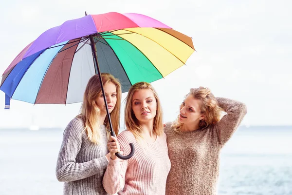 Tres mujeres bajo paraguas colorido — Foto de Stock