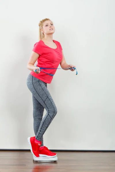 Vrouw het dragen van sportkleding staande op gewicht machine — Stockfoto