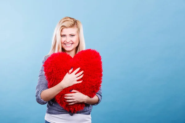 Mujer feliz sosteniendo almohada roja en forma de corazón — Foto de Stock