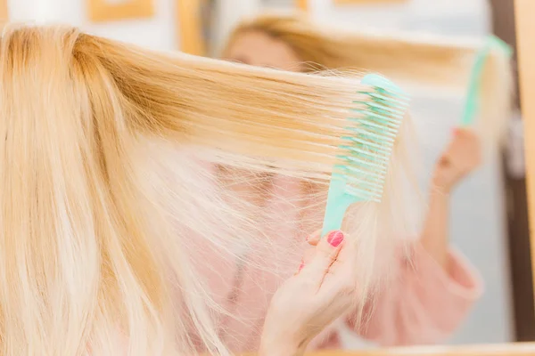 Mujer vestida con bata cepillándose el pelo — Foto de Stock