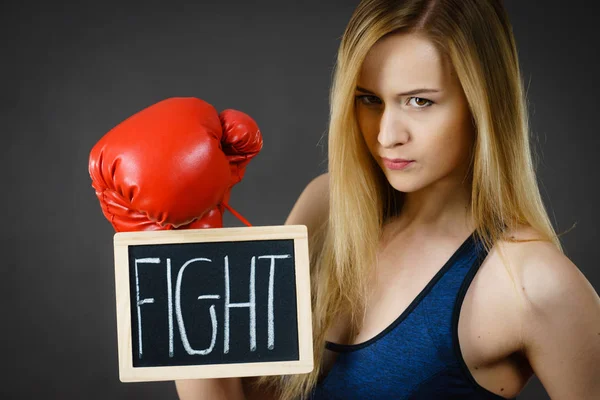 Mujer usando guante de boxeo sosteniendo signo de lucha —  Fotos de Stock