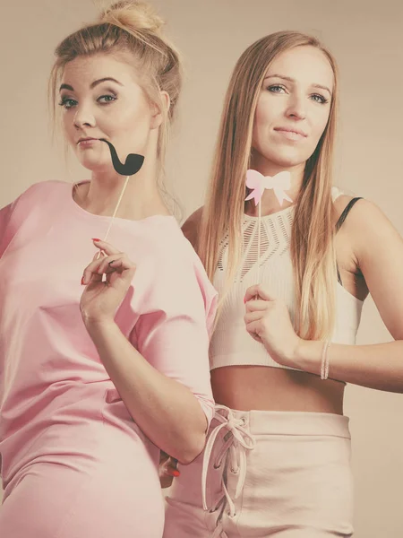 Two women holding carnival accessories — Stock Photo, Image