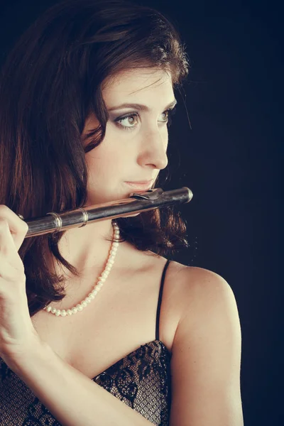 Woman playing transverse flute on black. — Stock Photo, Image