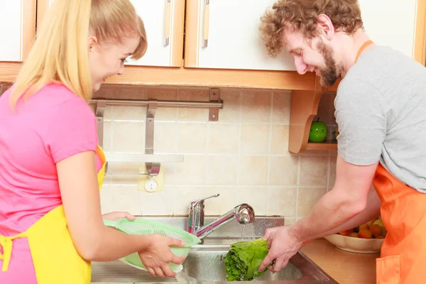Ζευγάρι πλύσιμο φρέσκα λαχανικά στην κουζίνα — Φωτογραφία Αρχείου