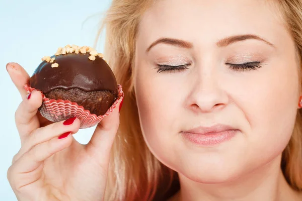 Woman holding chocolate cupcake about to bite — Stock Photo, Image