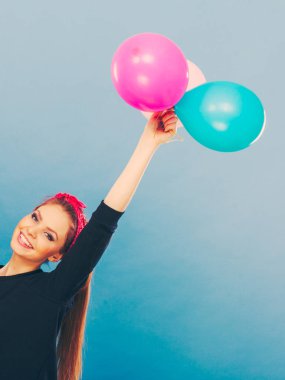 Balonlarla eğleniyor gülümseyen çılgın kız.