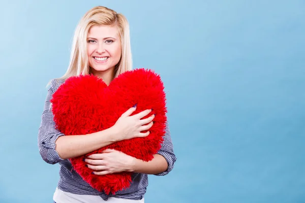 Mujer feliz sosteniendo almohada roja en forma de corazón —  Fotos de Stock