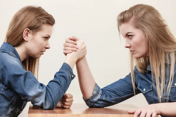 Two women having arm wrestling fight