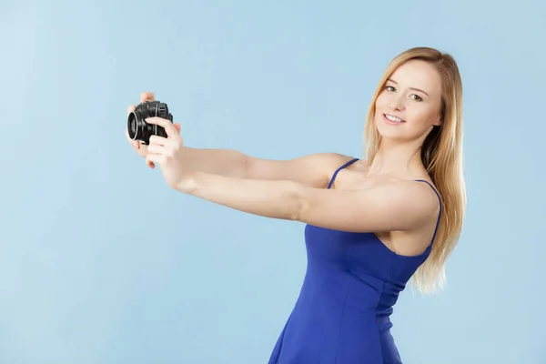 Блондинка с камерой на голубом — стоковое фото