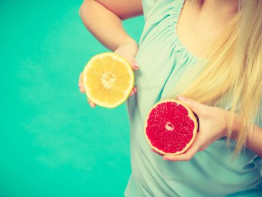 Kırmızı ve yeşil greyfurt tutan kadın