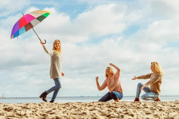 Mujeres sosteniendo paraguas divirtiéndose con amigos —  Fotos de Stock