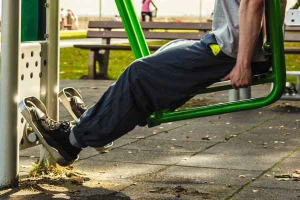 Hombre activo haciendo ejercicio en la pierna prensa al aire libre . — Foto de Stock