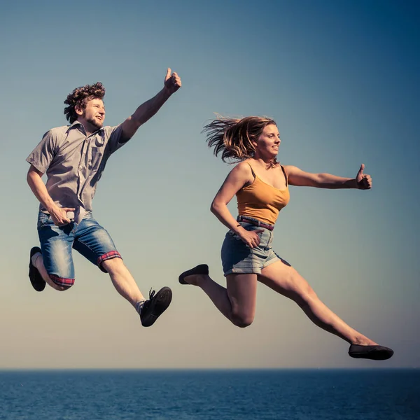 Carefree couple jumping by sea ocean water. — Stock Photo, Image