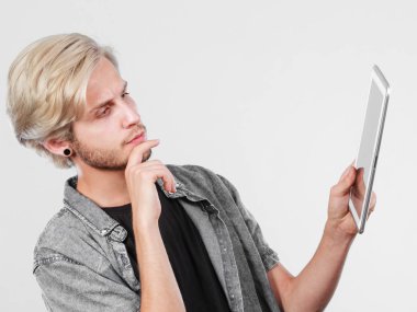 Tablet düşünme kullanarak trendy genç adam
