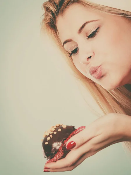 Donna che tiene un cupcake al cioccolato in procinto di mordere — Foto Stock