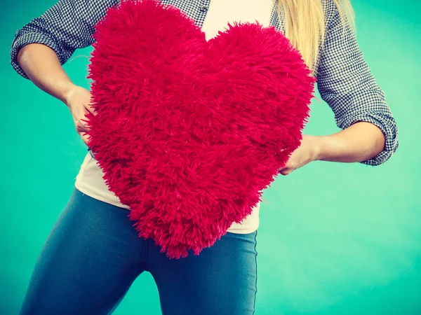 Mujer sosteniendo almohada roja en forma de corazón — Foto de Stock