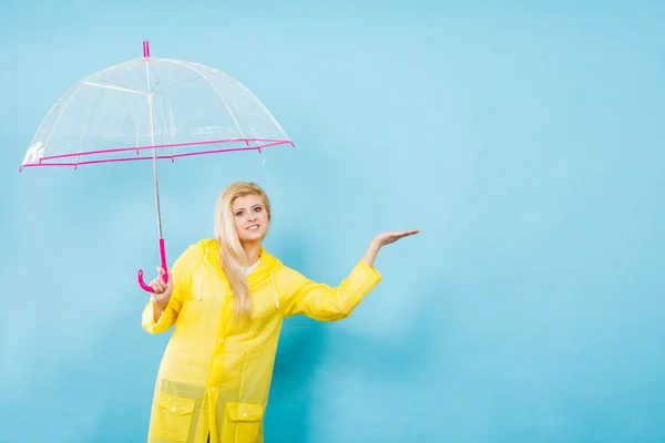 Mujer vistiendo impermeable sosteniendo paraguas comprobando el clima — Foto de Stock