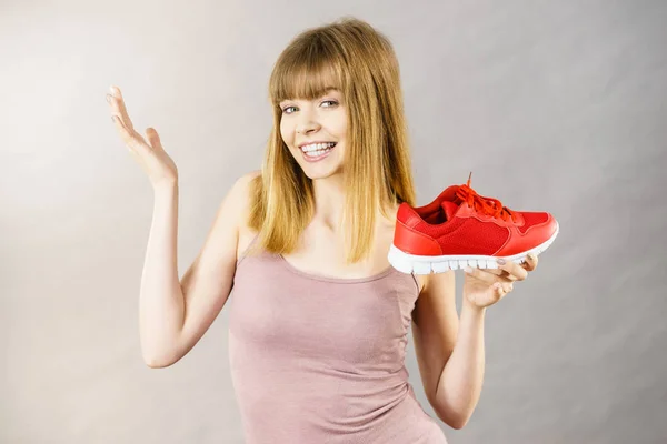 Mujer feliz presentando zapatillas deportivas zapatillas —  Fotos de Stock