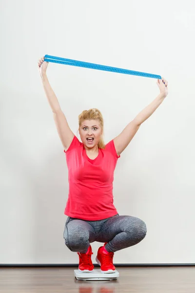 Woman wearing sportswear standing on weight machine — Stock Photo, Image