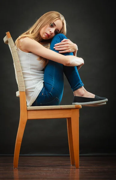 Oung λυπημένη γυναίκα που κάθεται στην καρέκλα — Φωτογραφία Αρχείου