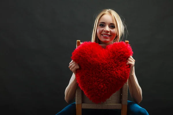Mujer sosteniendo corazón en forma de almohada símbolo de amor — Foto de Stock
