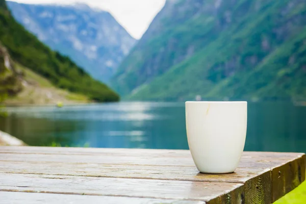 Mug on wooden table, fjord norwegian landscape — Stock Photo, Image