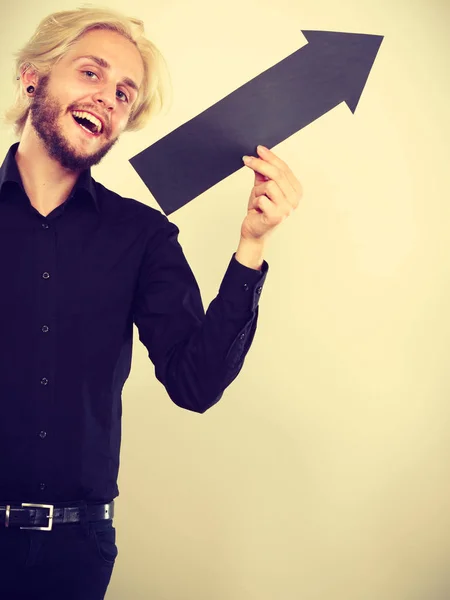 Hombre sosteniendo flecha negra apuntando a la derecha — Foto de Stock