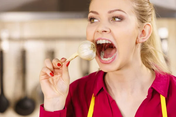 Сумасшедшая девушка ест чеснок овощ — стоковое фото