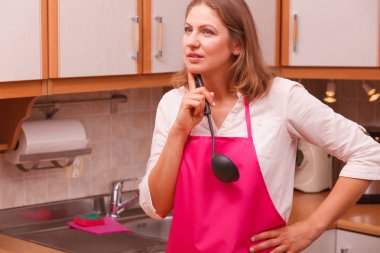 Ev kadını mutfakta kepçe ile