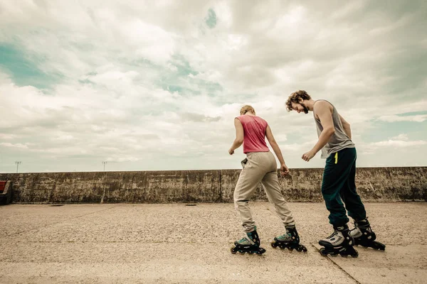 Dos personas corren juntas montando patines . — Foto de Stock