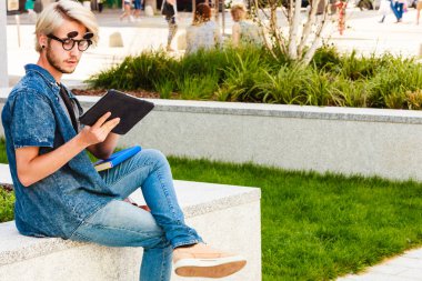 Hipster adam kenarında oturan tablet ile