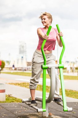 Aktif kadın üzerinde eliptik eğitmen egzersiz.