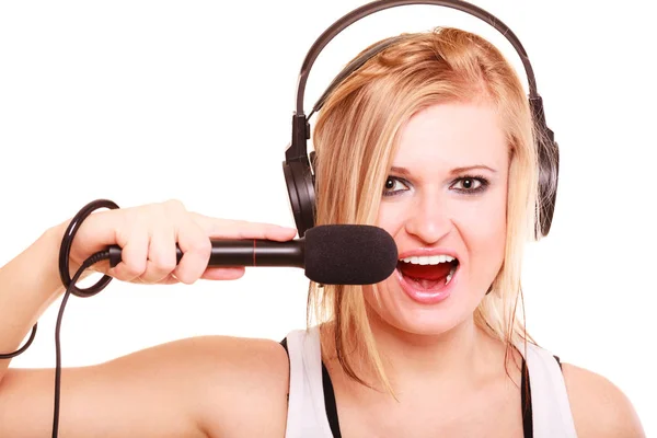 Kvinnan som sjunger till mikrofon bär hörlurar — Stockfoto