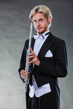 Zarif giyimli müzisyen flüt tutan