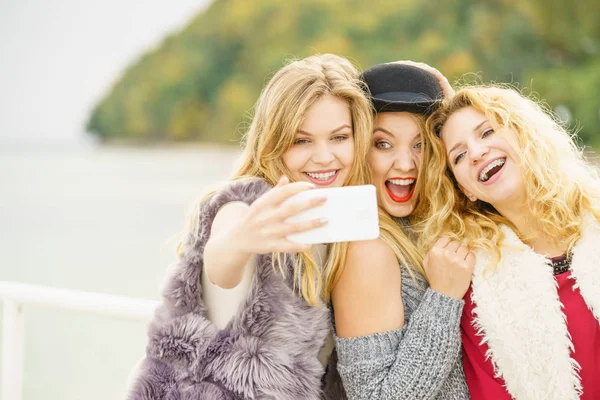 Três mulheres tomando selfie ao ar livre — Fotografia de Stock