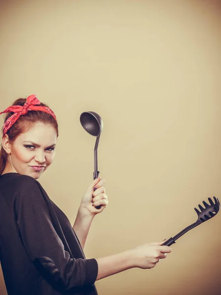 Mujer de estilo retro divirtiéndose con accesorios de cocina . — Foto de Stock