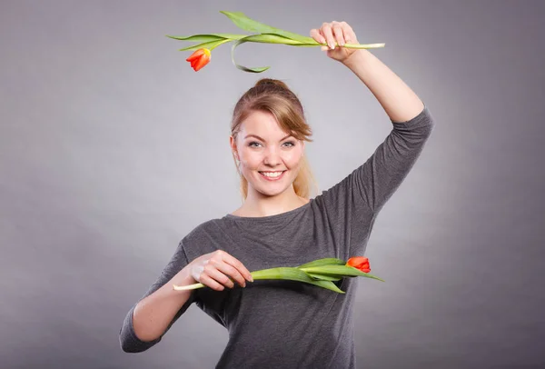 Zabawna Dziewczyna zabawy z kwiatów tulipany. — Zdjęcie stockowe