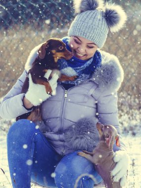 Köpeklerle kış aylarında oynayan kadın
