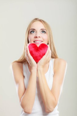 Gülümseyen kadın holding kırmızı kalp aşk sembolü