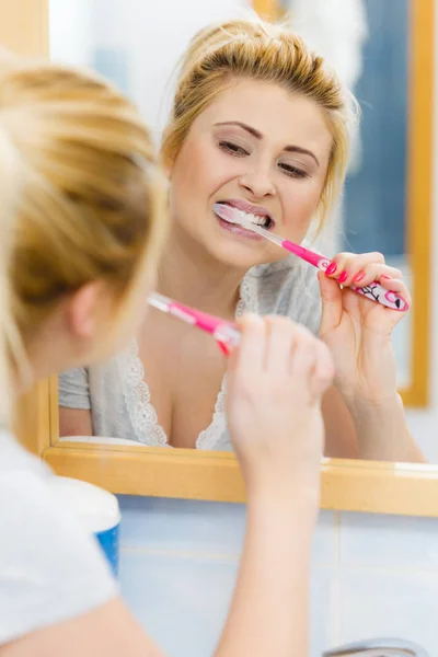 Woman brushing cleaning teeth in bathroom — Stock Photo, Image