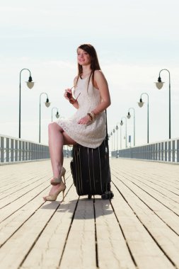 Çanta, arka planda iskele üzerinde oturan kadın