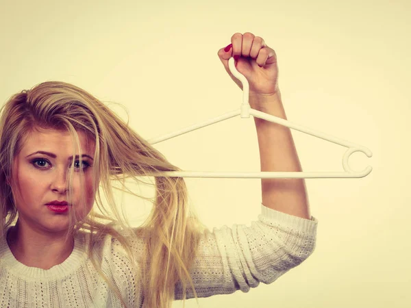 Mulher segurando o cabelo no cabide de roupas — Fotografia de Stock