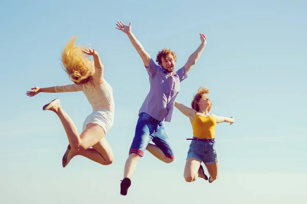 Groupe d'amis garçon deux filles sautant en plein air — Photo