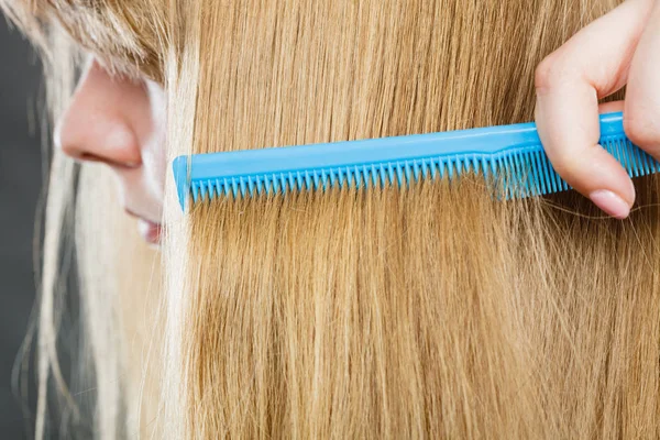 Primer plano de peine azul en cabello rubio . — Foto de Stock