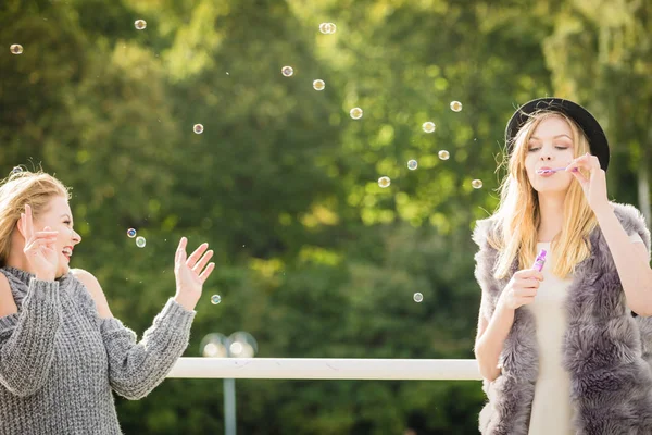 Mulheres amigas soprando bolhas de sabão . — Fotografia de Stock