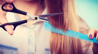 Uzun düz saçları kesmeye hazır kız.