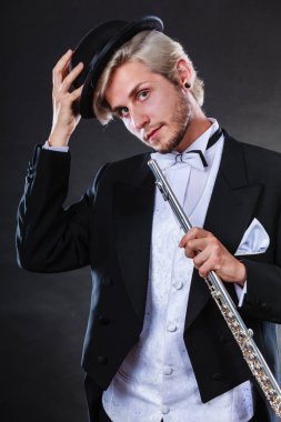 Zarif giyimli müzisyen flüt tutan