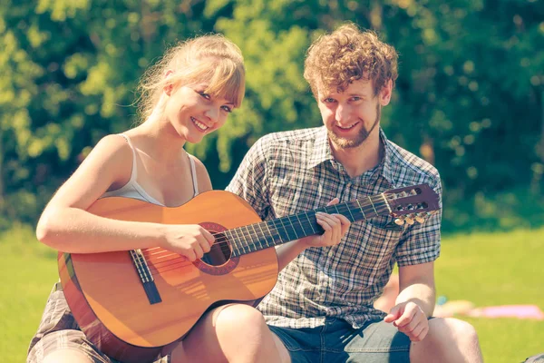 Giovane coppia campeggio suonare la chitarra all'aperto — Foto Stock