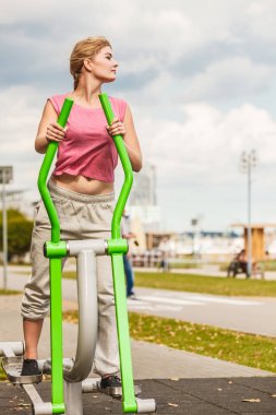 Aktif kadın üzerinde eliptik eğitmen egzersiz.