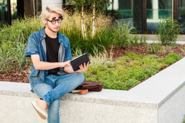 Hipster adam kenarında oturan tablet ile